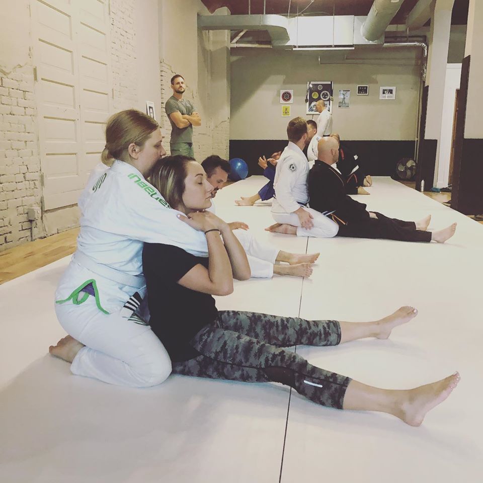 Women learning a self defense technique in Brazilian Jiu Jitsu Class